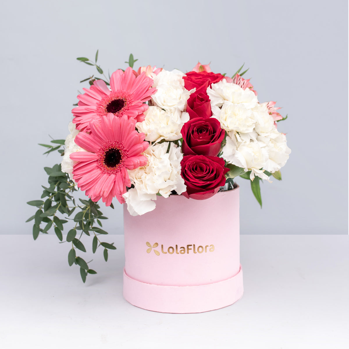 Pink alstroemeria, pink gerberas, and white daisies in a pink box