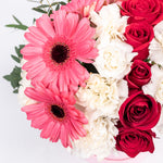 Pink alstroemeria, pink gerberas, and white daisies in a pink box