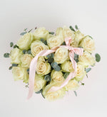 Rosa blanca y listón rosa en caja de corazón