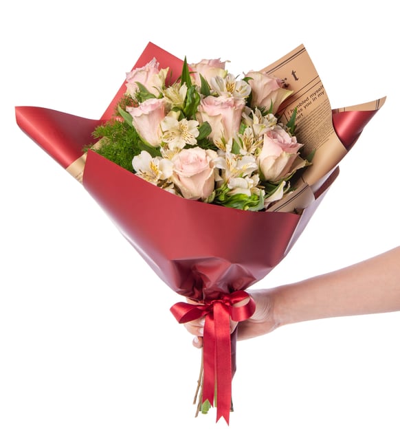 Astromelia blanca y rosa rosa en ramo de papel periódico burdeos