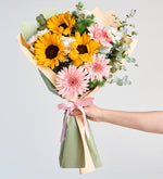 Girasol, margarita blanca y gerbera rosa en un elegante ramo