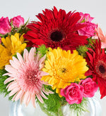 Gerberas de colores en jarrón pecera