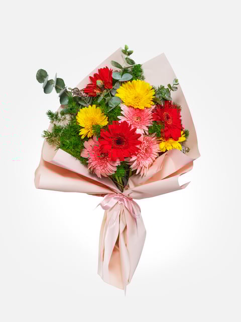 Gerberas coloridas en un ramo rosa pastel