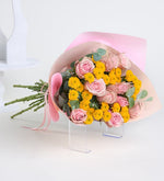 Rosa rosa y crisantemo amarillo en un ramo rosa pastel