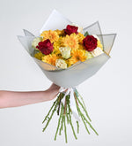 Rosa roja, margarita amarilla y gerbera amarilla en ramo gris