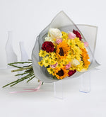 Girasol, rosa rosa y margarita amarilla en ramo gris
