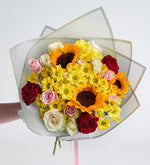 Girasol, rosa rosa y margarita amarilla en ramo gris