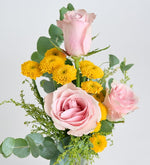Rosa rosa y crisantemo amarillo en un jarrón de cristal