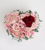 Rosa rosa, roja y eucalipto en caja de corazón