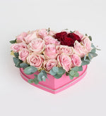 Rosa rosa, roja y eucalipto en caja de corazón