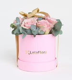 Rosa rosa, eucalipto y listón amarillo en caja rosa