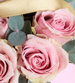 Rosa rosa, eucalipto y listón amarillo en caja rosa
