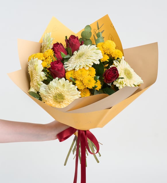 Rosas rojas y crisantemos amarillos en un ramo amarillo