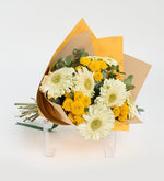 Gerberas blancas y crisantemos amarillos en un ramo amarillo