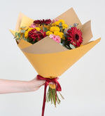 Gerberas rojas y rosas rosas en un ramo amarillo (A)