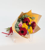 Gerberas rojas y rosas rosas en un ramo amarillo (A)