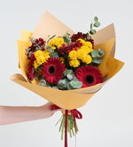 Gerberas rojas y crisantemos amarillos en un ramo amarillo
