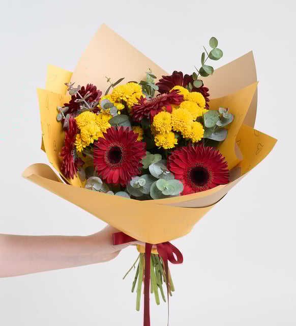 Gerberas rojas y crisantemos amarillos en un ramo amarillo