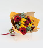 Gerberas rojas y crisantemos amarillos en un ramo amarillo
