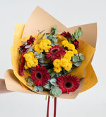Gerberas rojas y crisantemos amarillos en un ramo amarillo