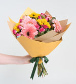 Rosas mini y gerberas rosas en un ramo amarillo