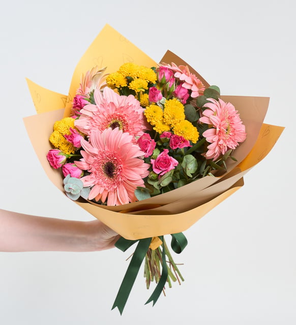 Rosas mini y gerberas rosas en un ramo amarillo