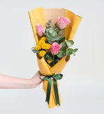 Rosas rosas y crisantemo con eucalipto en ramo amarillo