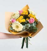 Rosas rosas y gerberas blancas en un ramo amarillo