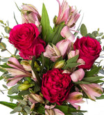 Rosas fucsias y flores astromelias rosas en florero de cristal