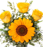 Rosas amarillas y girasoles en florero cilíndrico