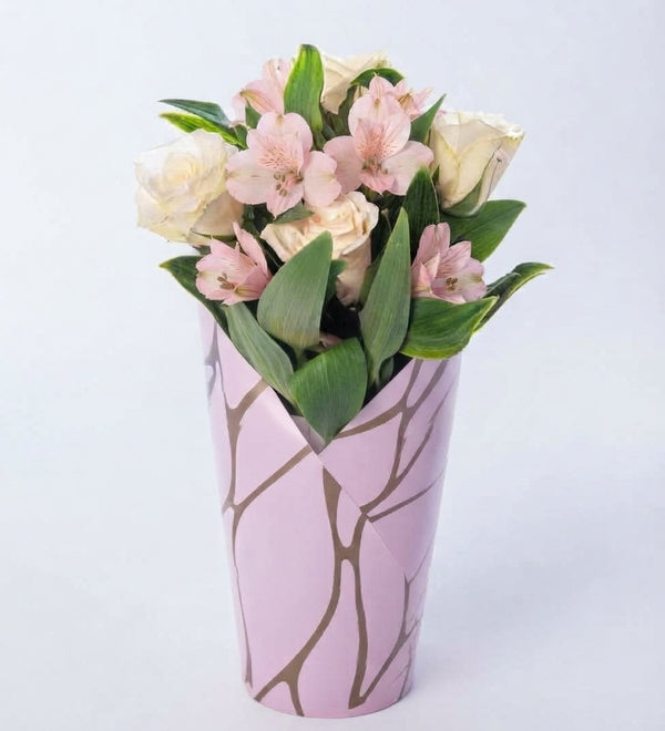 White roses and red alstroemerias in a pink decorative box