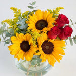 Sunflower and red rose and white daisy in a fishbowl vase