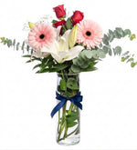 White lilies, red roses, and gerbera daisies in a vase