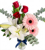 White lilies, red roses, and gerbera daisies in a vase