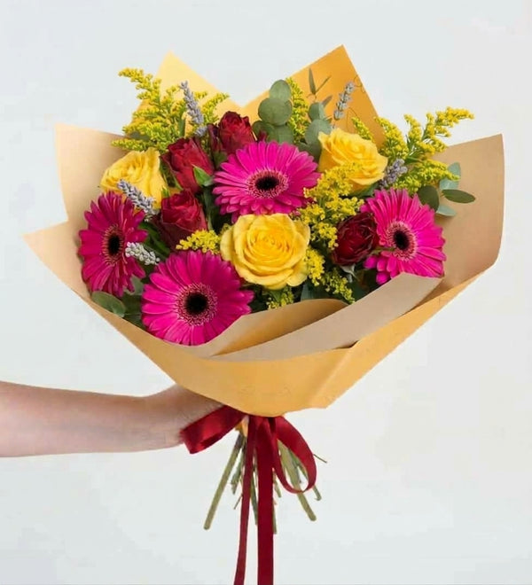 Red roses and yellow chrysanthemums in a yellow bouquet